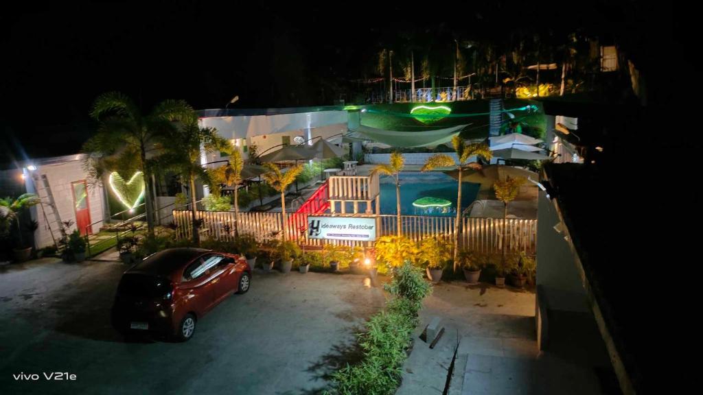 um carro estacionado em frente a uma casa à noite em Hideaways Restobar and Resort 