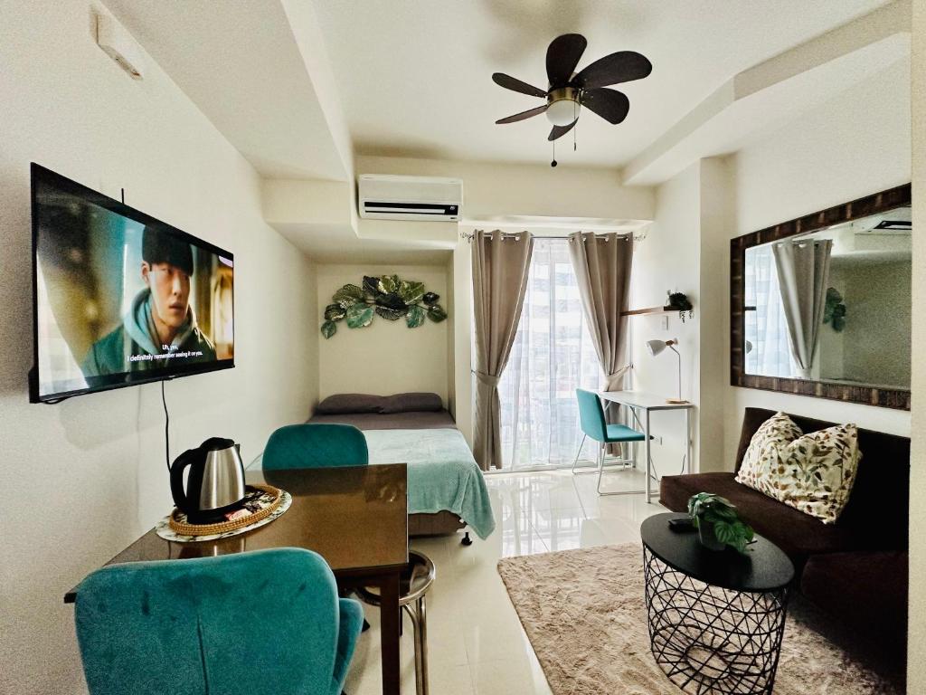 sala de estar con cama y TV en la pared en Lengs Place 2 - Studio Unit with Balcony at Inspiria Condo, en Davao City