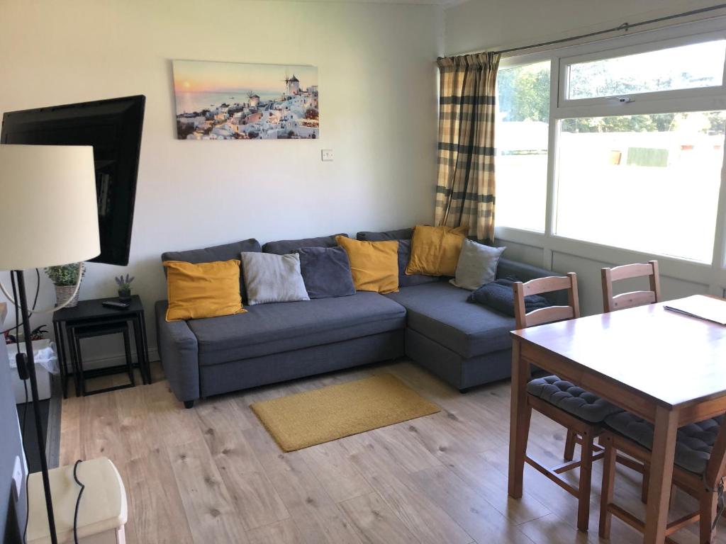 - un salon avec un canapé bleu et une table dans l'établissement The Cosy Cabin - Bideford Bay Holiday Park, à Bucks Mills