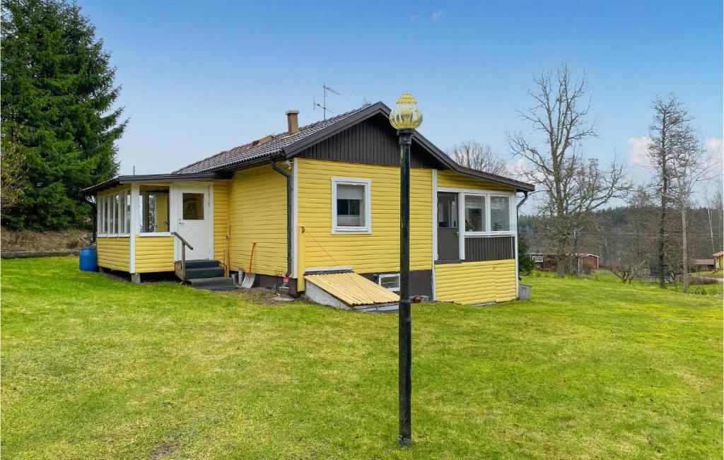 una pequeña casa amarilla en un campo de hierba en Beautiful Home In Mjlby With Ethernet Internet en Mjölby