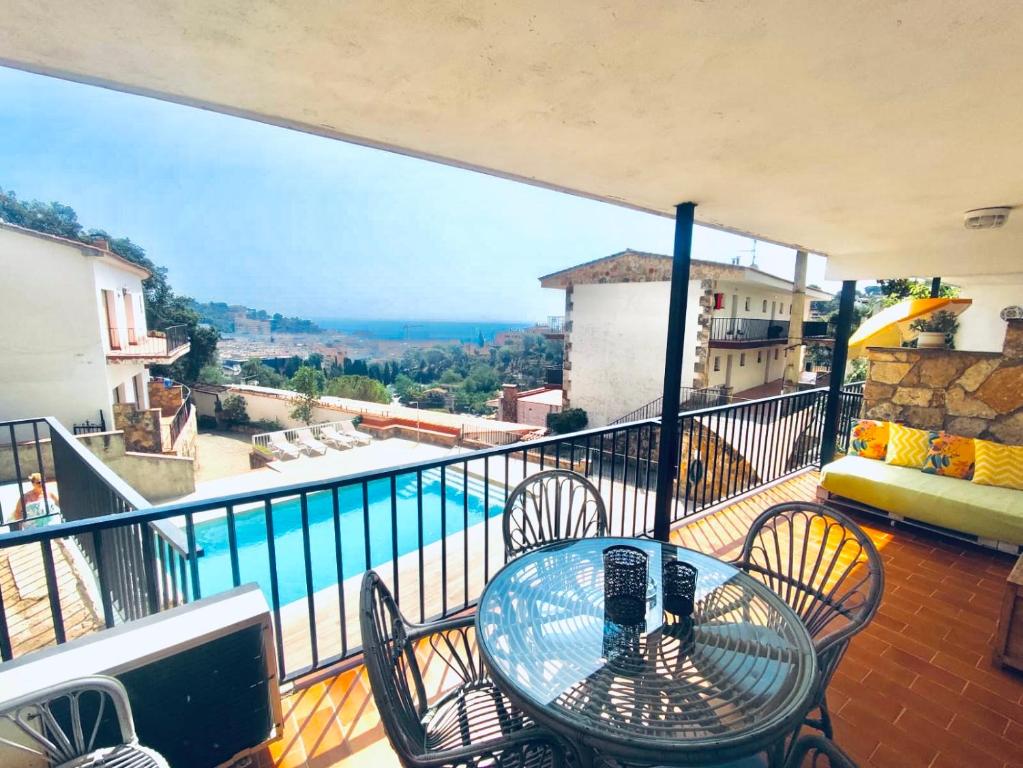 balcón con mesa, sillas y piscina en TOSSA DE MAR, MIRAMAR con piscina, en Tossa de Mar