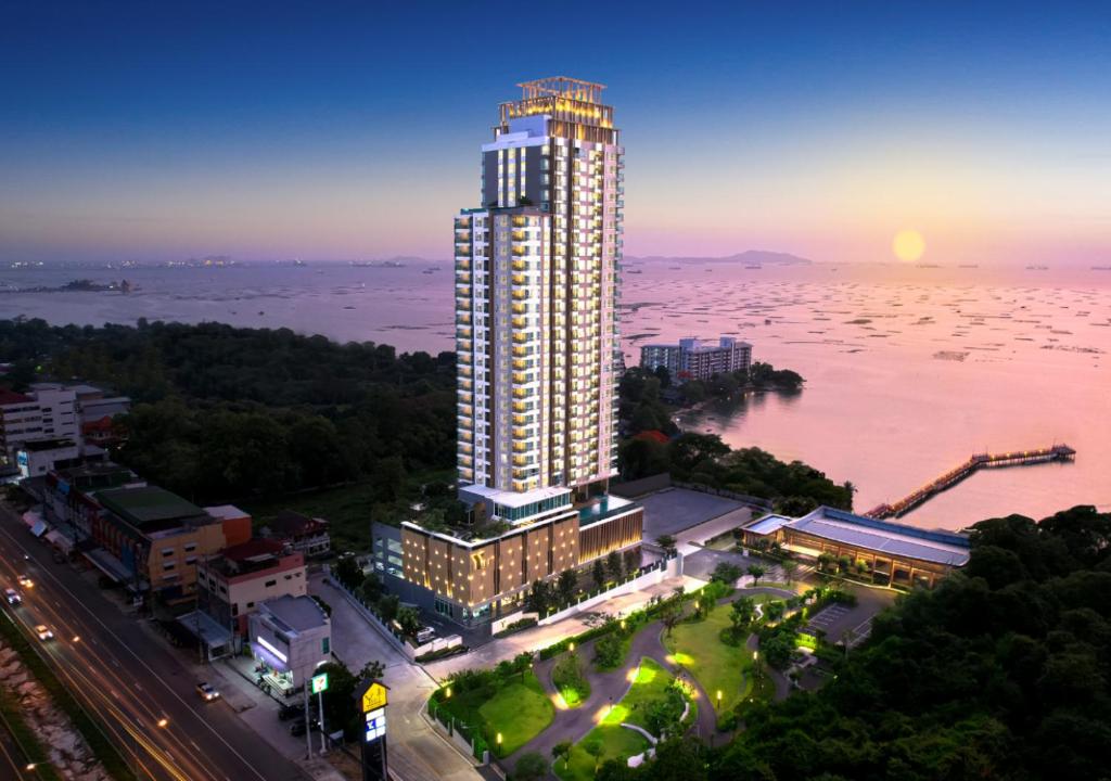 a tall building next to a large body of water at Yuu Residence in Si Racha
