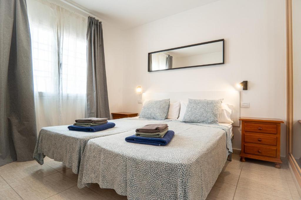 a bedroom with a bed with two towels on it at Las Casitas de Corralejo in Corralejo