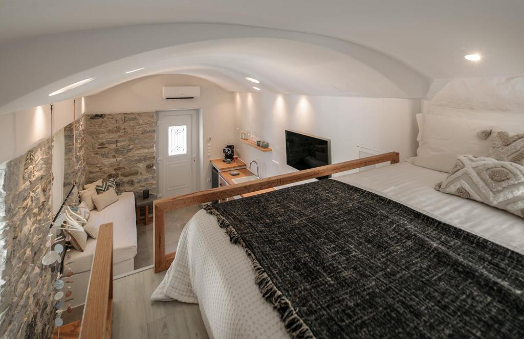 1 dormitorio con 1 cama grande y pared de piedra en "Voras Luxury Cave Loft", en Naxos Chora