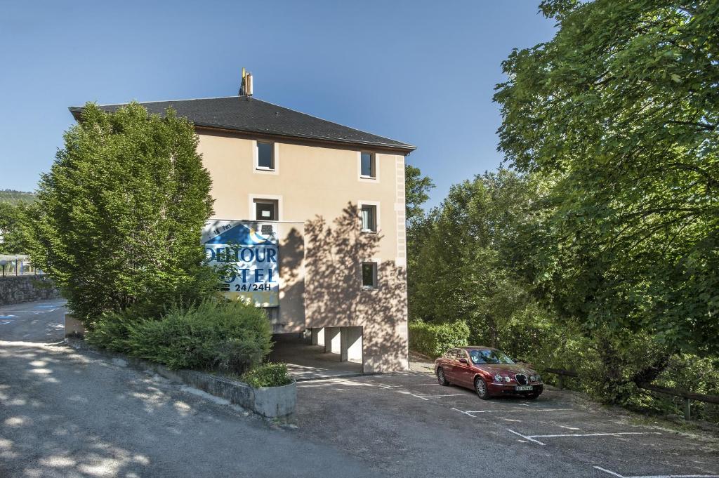 a red car parked in front of a building at Brit Hotel Essentiel Deltour Mende in Mende