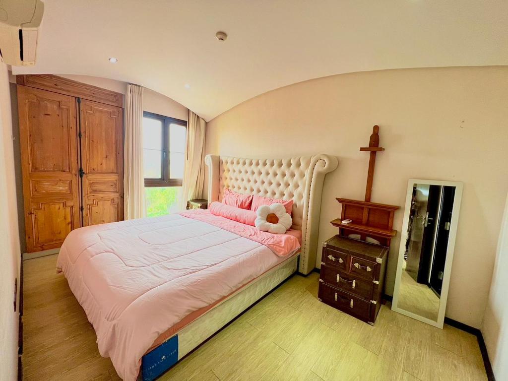 Un dormitorio con una cama rosa con un osito de peluche. en Venetian river view, en Jomtien Beach