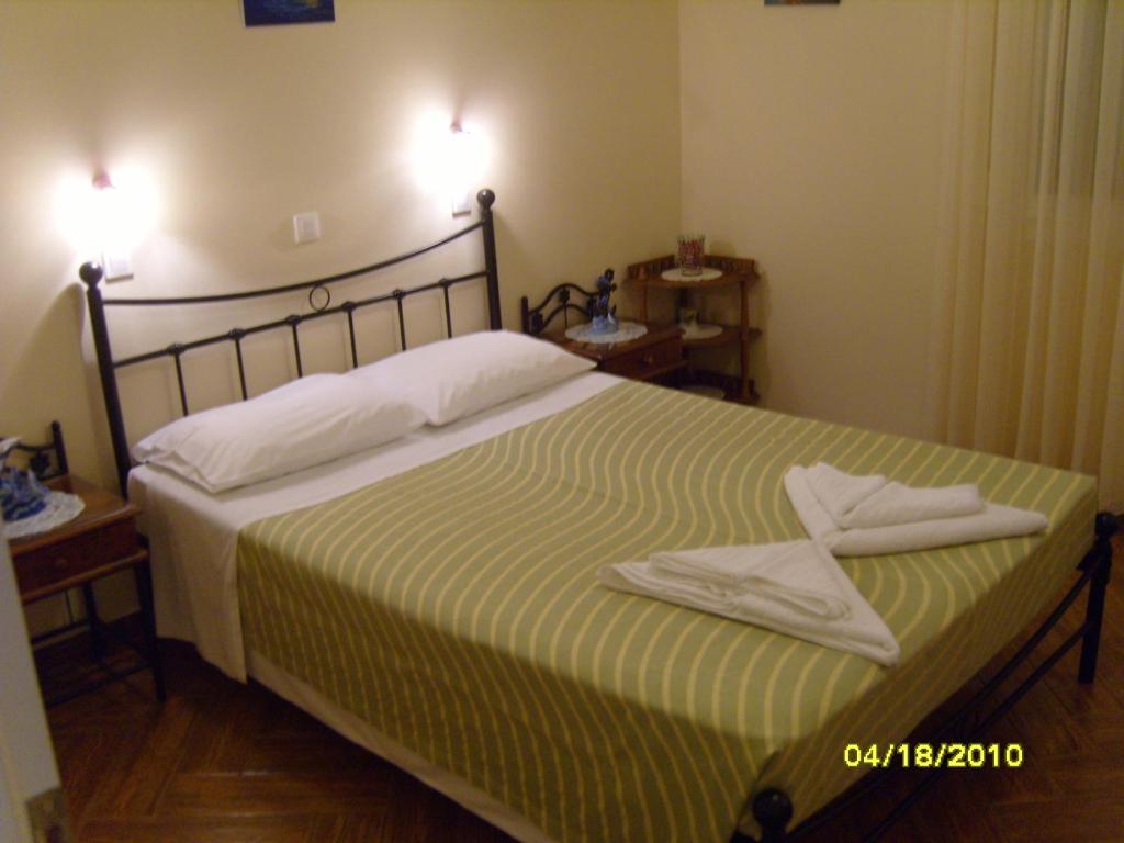 a bedroom with a bed with two towels on it at Elisabeth Villas in Kerveli