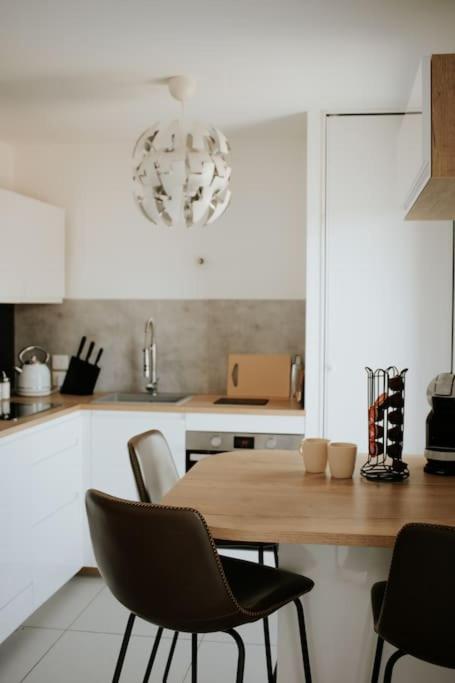 a kitchen with a wooden table and chairs at Spacieux Appart T3+terrasse in Aix-les-Bains