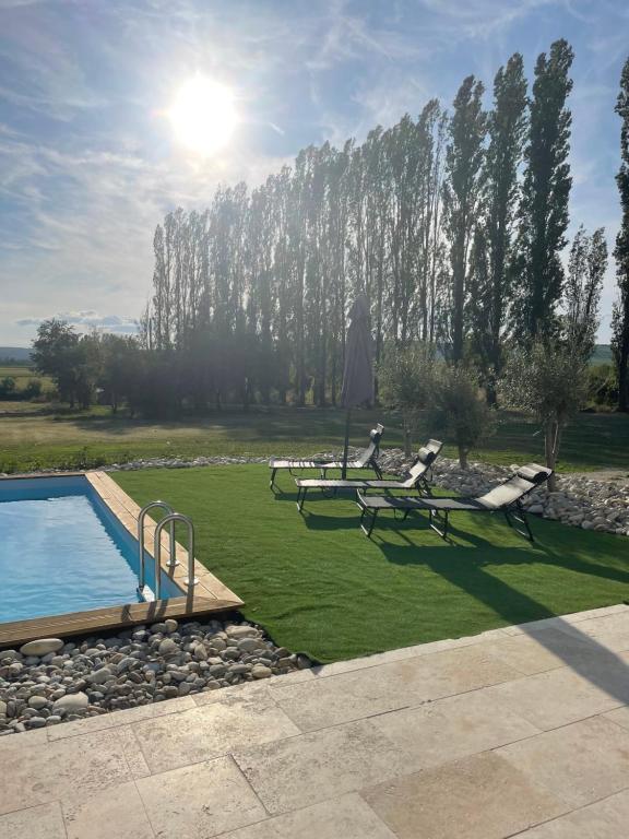 a garden with a pool and a table and chairs at Logement A / Clos des Saunières in Bligny-lès-Beaune