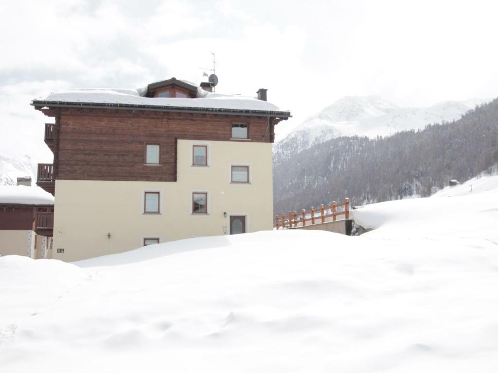 a building in the snow with snow covered roofs at Modern Holiday Home in Livigno Italy near Ski Area in Livigno