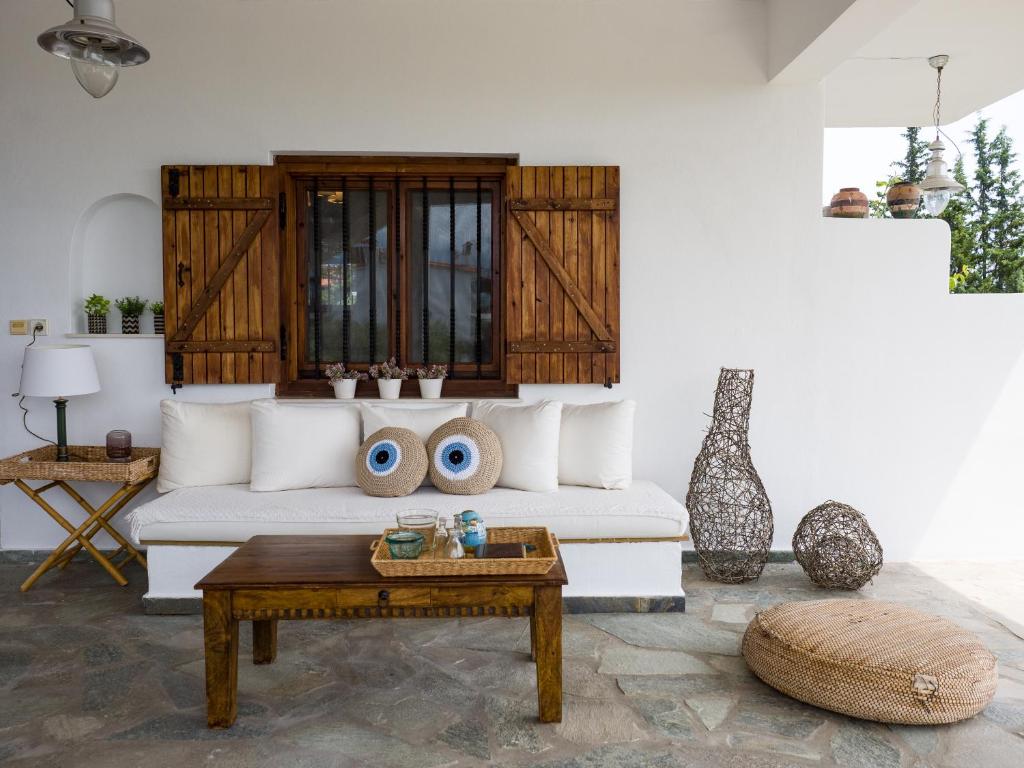 a living room with a white couch and a table at ZeusPlace Olympus Olive Country House 1 in Leptokaria