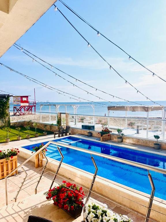 a swimming pool with a view of the ocean at KIR House On The Beach in Eforie Nord