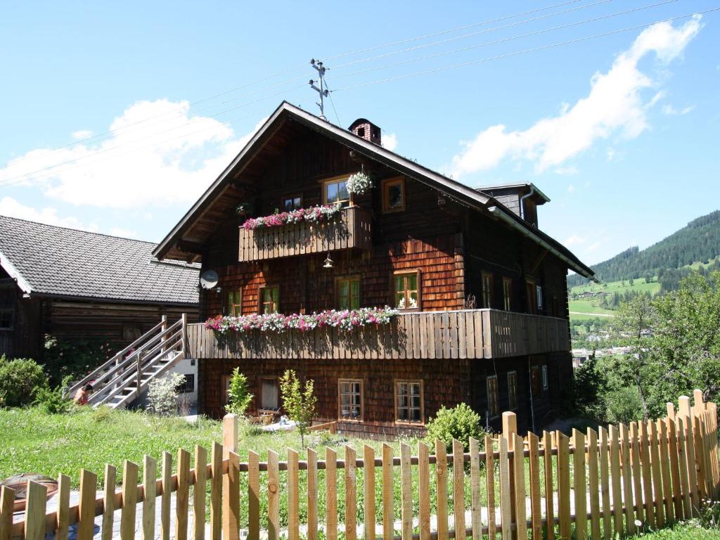 ein Holzhaus mit Blumen auf dem Balkon in der Unterkunft Sprawling Mansion near Ski Area in Salzburg in Eben im Pongau