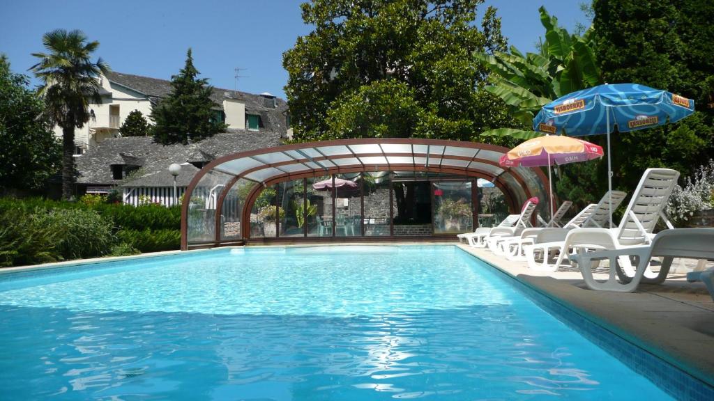 - une piscine bordée de chaises longues et de parasols dans l'établissement Hôtel du Lion d'Or, à Entraygues-sur-Truyère