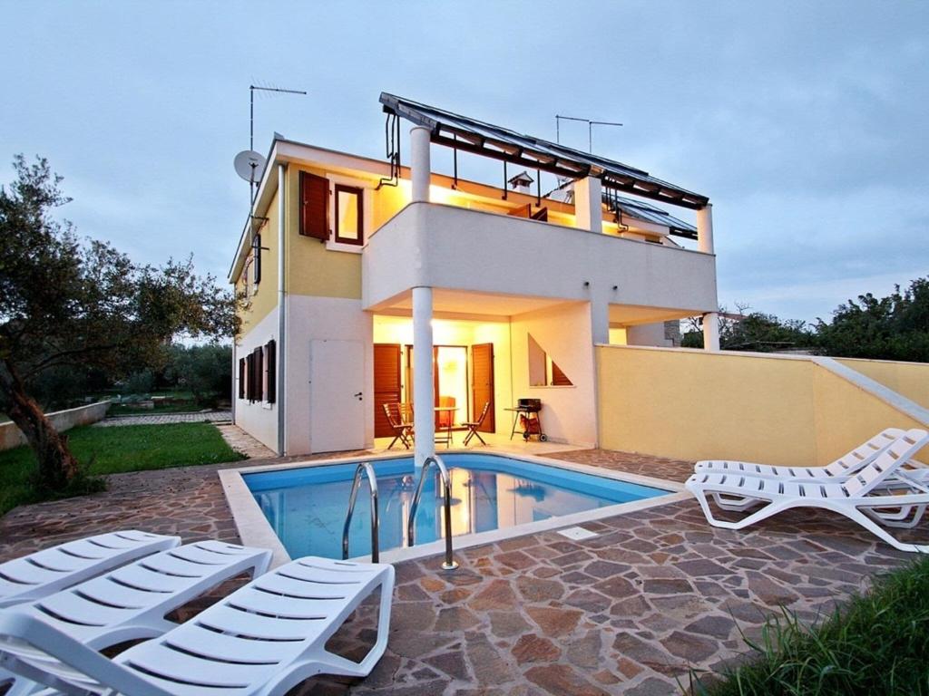 eine Villa mit einem Pool und einem Haus in der Unterkunft Splendid Holiday Home in Novigrad near sea in Novigrad Istria
