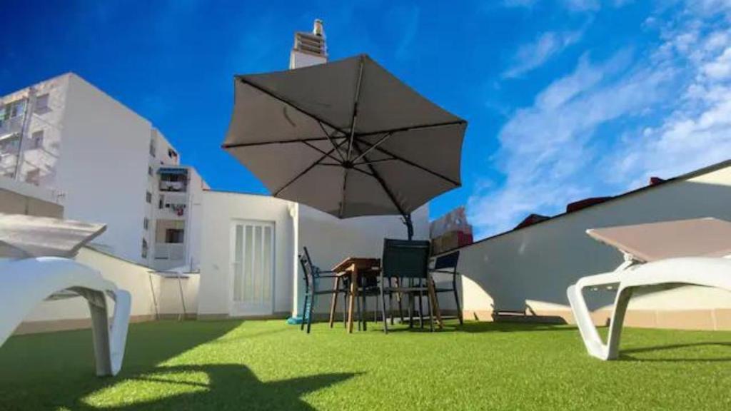 a patio with an umbrella and a table and chairs at AVA Flats in Alicante