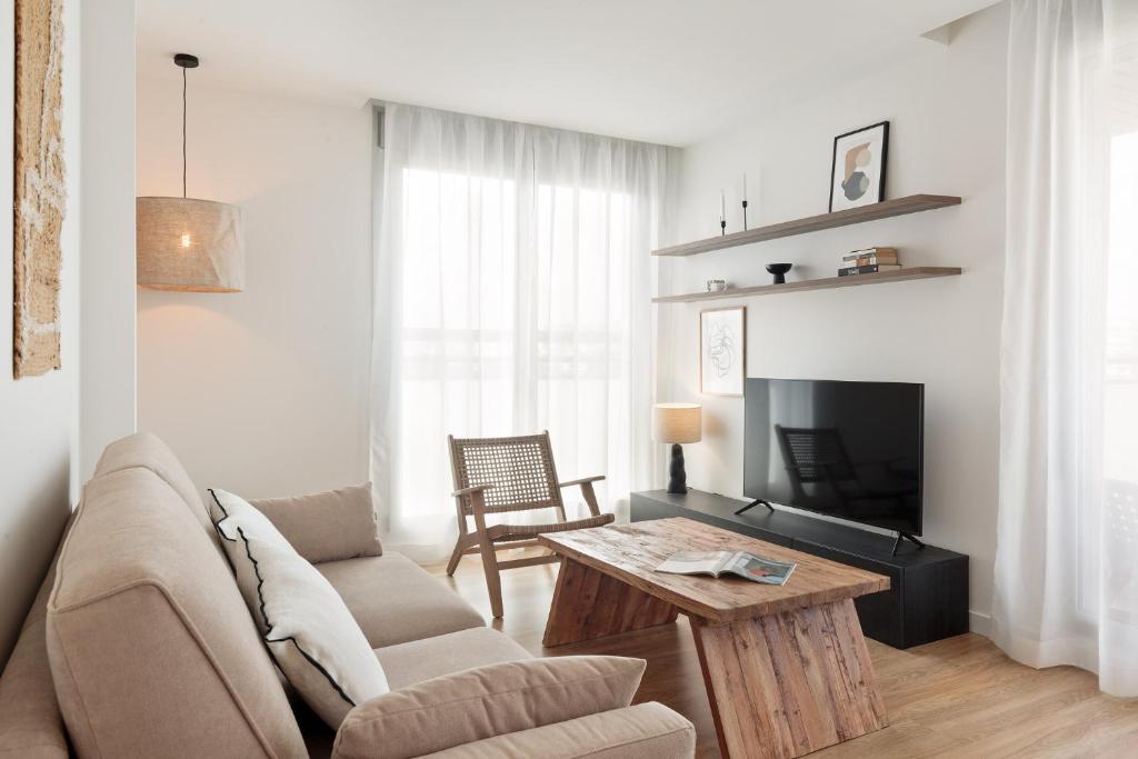 巴塞隆納的住宿－Port Forum Apartments by Olala Homes，带沙发和咖啡桌的客厅