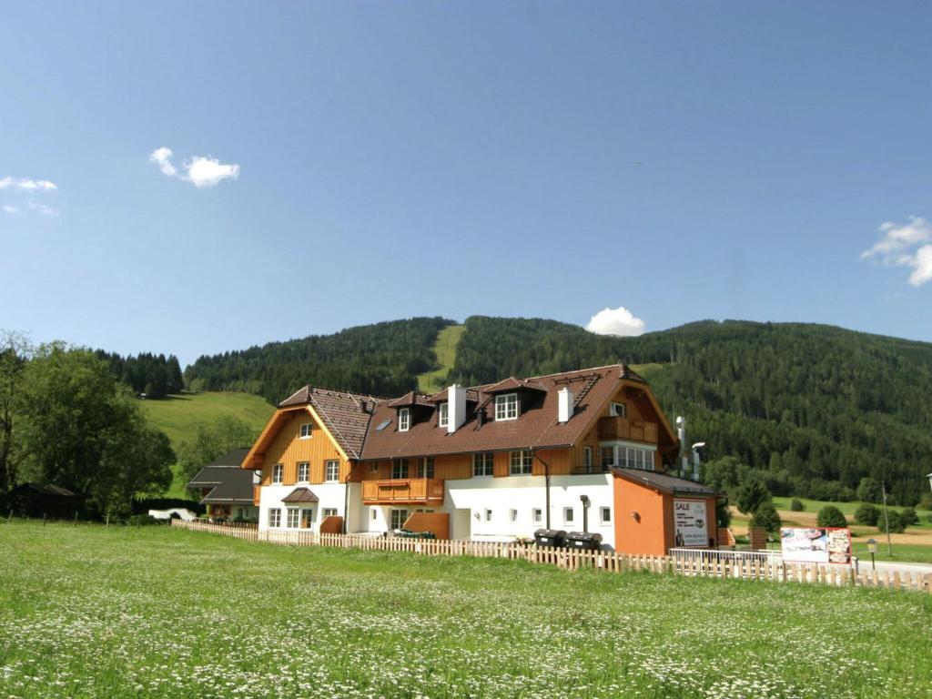 ein großes Haus auf einem Hügel mit grünem Feld in der Unterkunft Vogue Apartment in Sankt Margarethen im Lungau near Ski Lift in Sankt Margarethen im Lungau