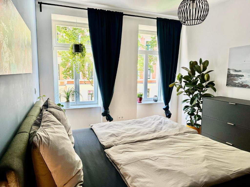 a bedroom with a bed and two windows at Wohlfühloase im hippen Leipziger Osten in Leipzig