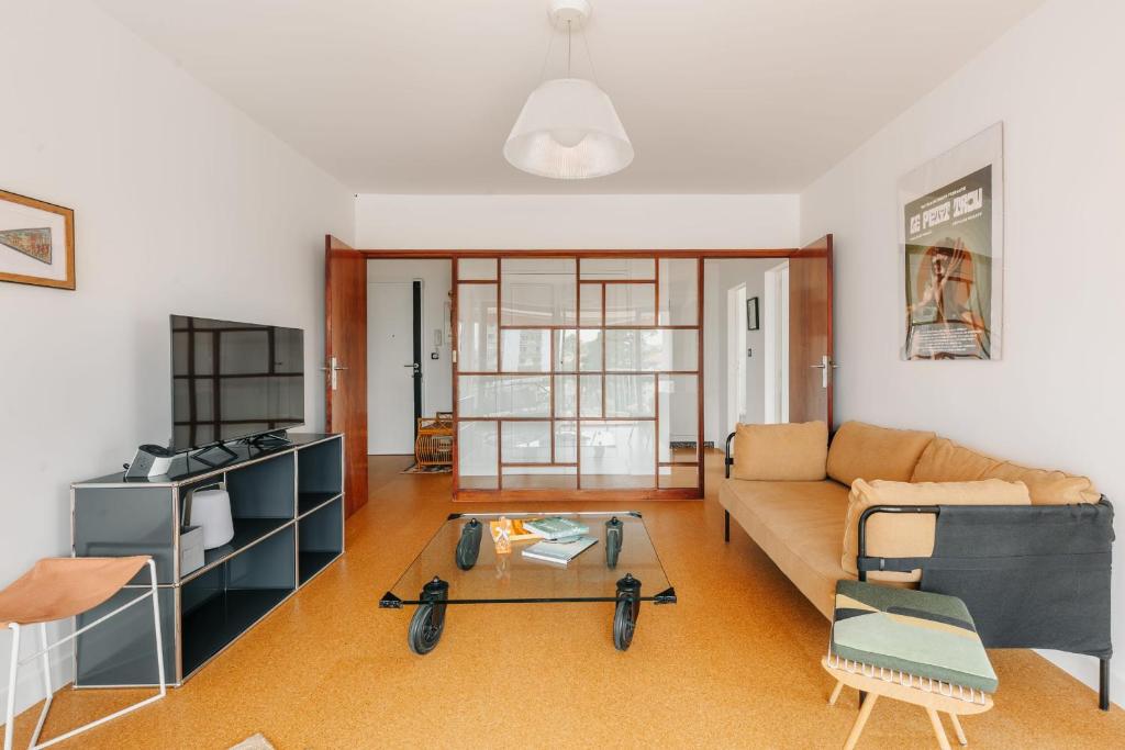 un soggiorno con divano e tavolo di Sixties 64 2 bedrooms apartment with a balcony and parking in Biarritz a Biarritz