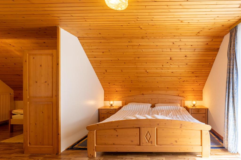 uma cama num quarto com tecto em madeira em Apartment Malej em Bohinj