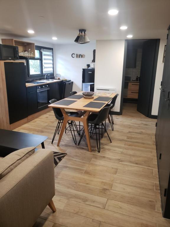 une salle à manger et une cuisine avec une table et des chaises dans l'établissement COSY, à Coubron