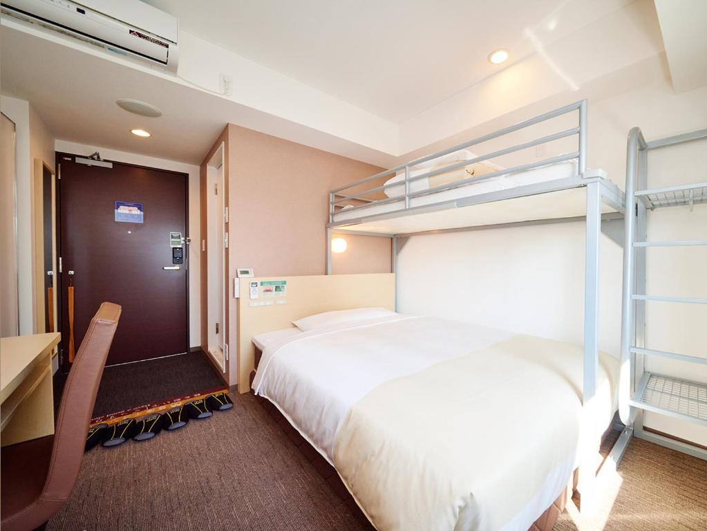 a hotel room with a bed and bunk beds at Super Hotel Akihabara Suehirocho in Tokyo