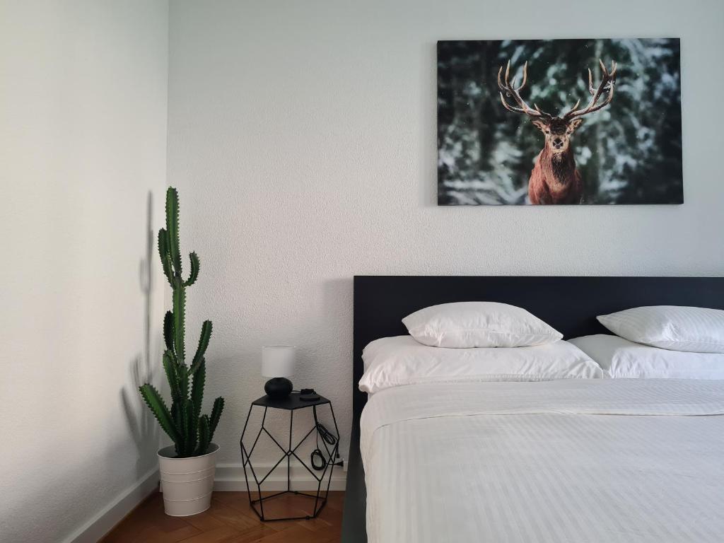 a bedroom with a bed with a picture of a deer at 2 BR - Kingsize Bett - Garten - Parken - Küche in Zürich