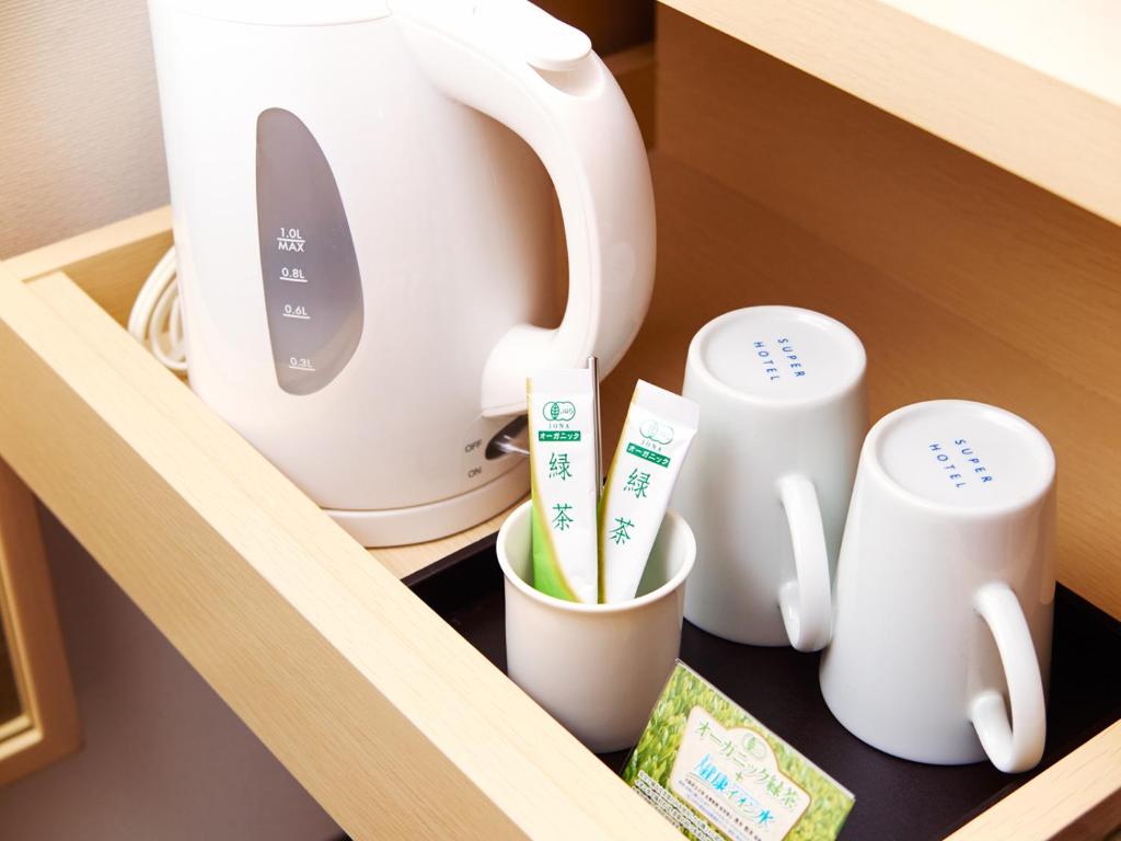 a shelf with cups and a toaster and toothbrushes at Super Hotel Akihabara Suehirocho in Tokyo