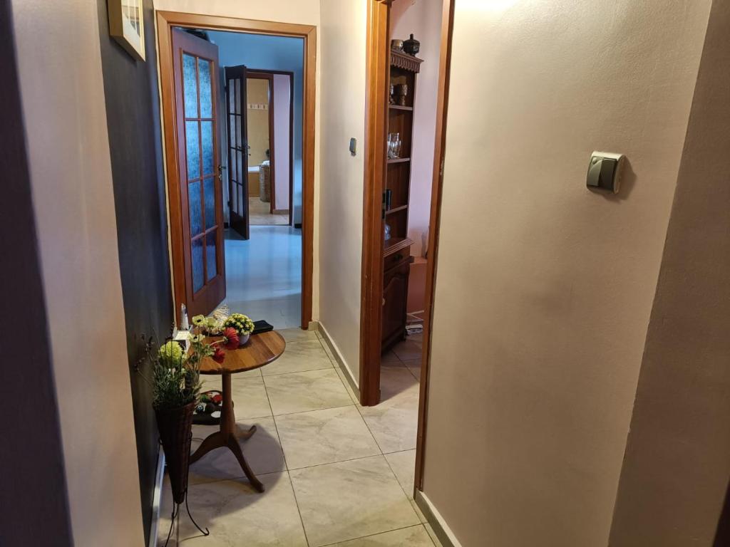 un pasillo con una mesa y una puerta a una habitación en Grati’s house, en Constanţa