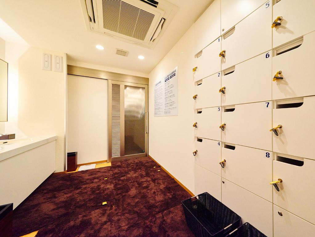 a room with a wall of lockers and a window at Super Hotel Akihabara Suehirocho in Tokyo