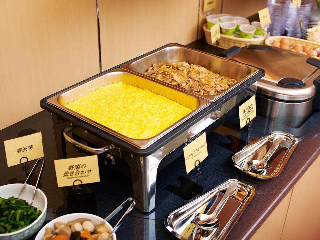 a buffet of food on a counter in a restaurant at Super Hotel Akihabara Suehirocho in Tokyo