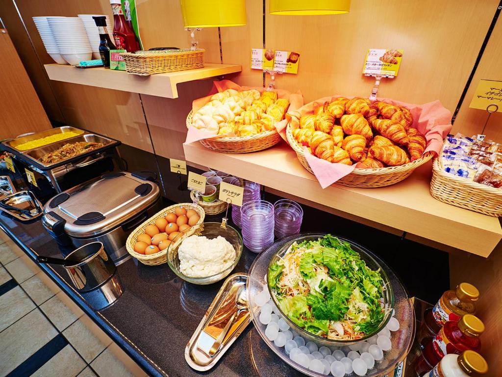 a counter with many different types of food on it at Super Hotel Akihabara Suehirocho in Tokyo