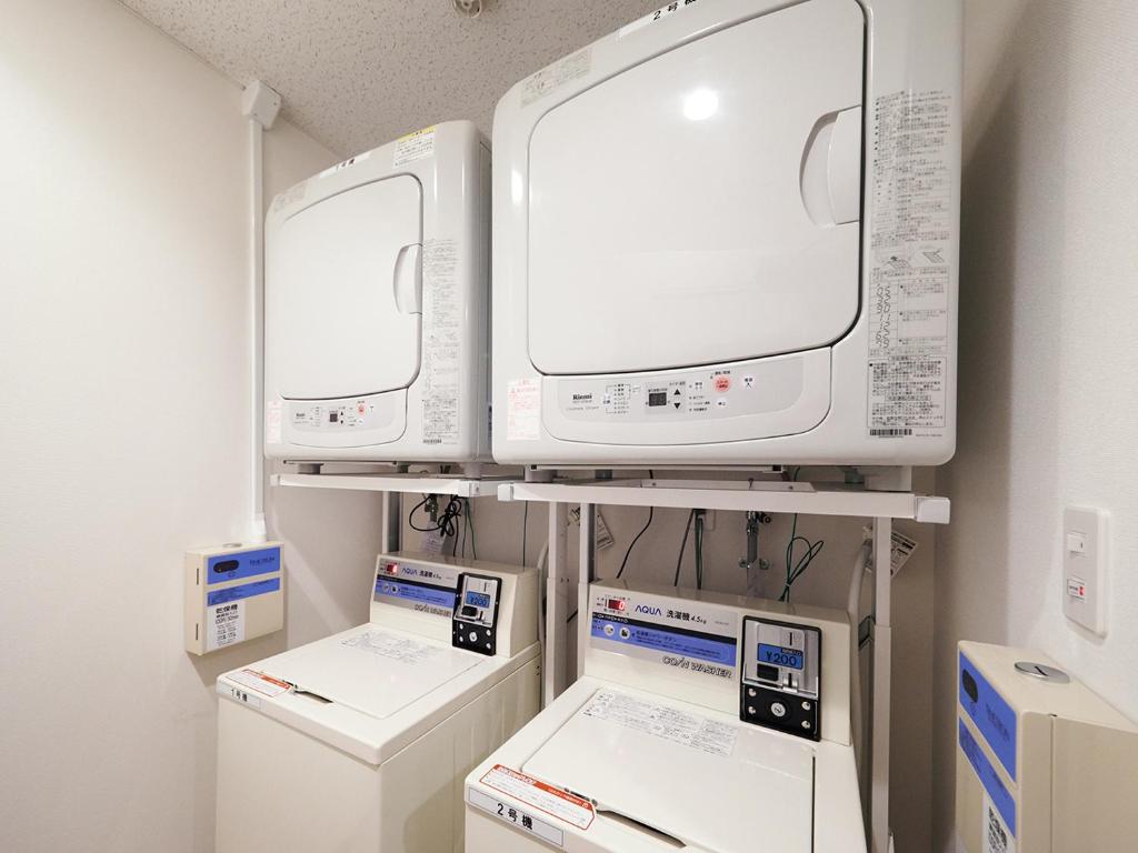 a room with two monitors and other appliances on a shelf at Super Hotel Akihabara Suehirocho in Tokyo