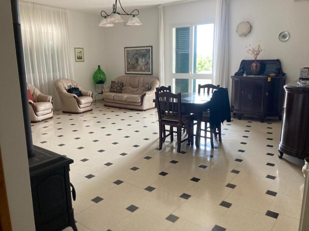 sala de estar con mesa y sillas en Casa vacanza IL MELOGRANO Giuggianello (Lecce), en Giuggianello