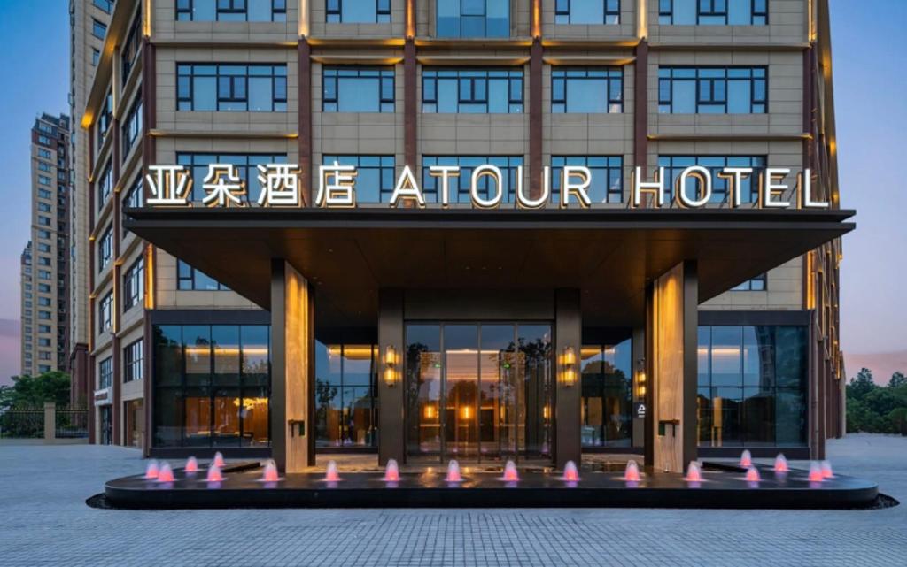 a building with a sign on the front of it at Atour Hotel Huanggang Middle School in Huangzhou