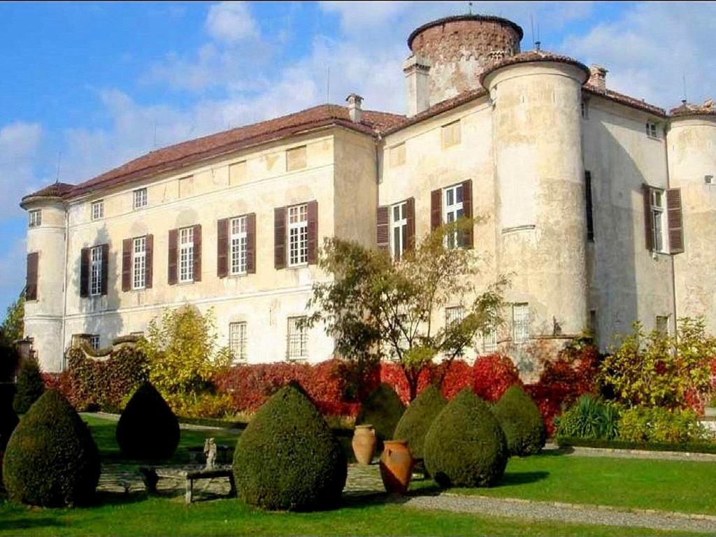 un gran edificio con un montón de arbustos delante de él en Luxurious Apartment in Rocca Grimalda with Garden, en Rocca Grimalda