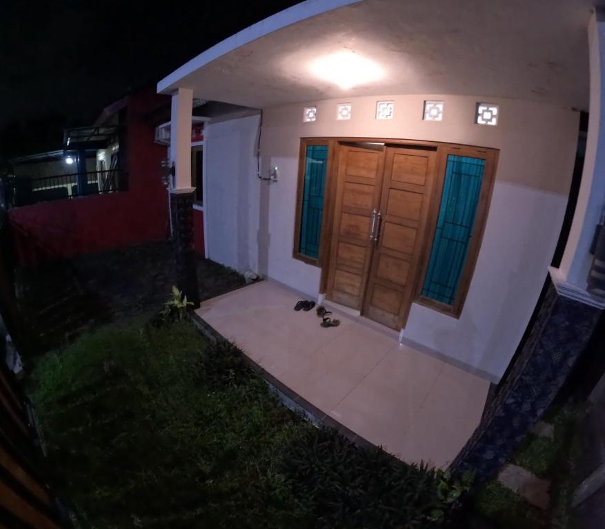 a cat sitting outside of a house at night at Bovalia Homestay Jogja in Seturan