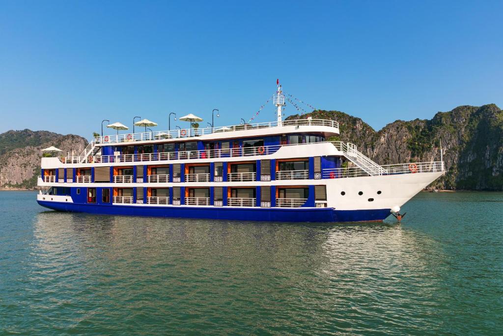 Halong Dragon Bay Cruise في ها لونغ: سفينة الرحلات البحرية في المياه مع الجبال في الخلفية