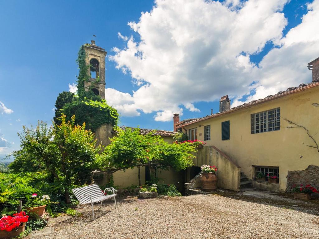 ein Haus mit einem Uhrturm im Hintergrund in der Unterkunft Cosy Farmhouse in Bacchereto with Swimming Pool in Carmignano