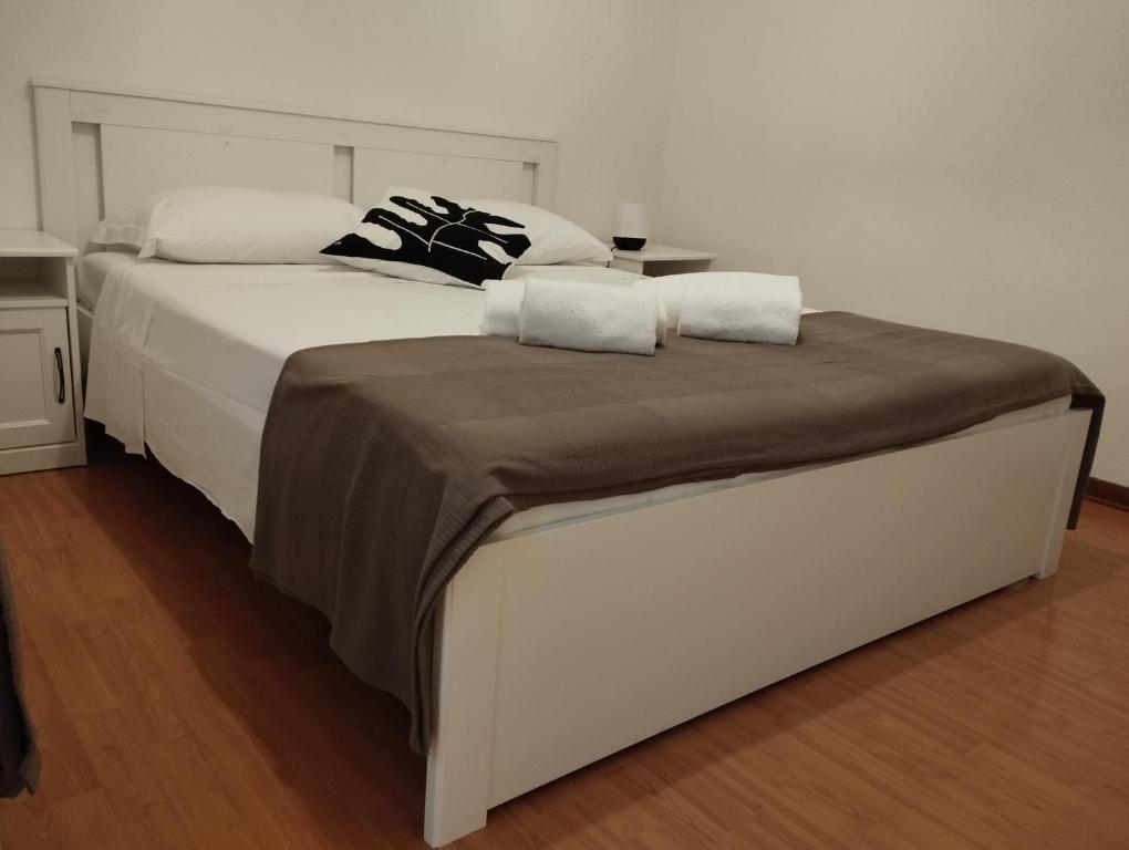 een groot wit bed met 2 kussens erop bij DormiTrieste City Life Apartment in Trieste