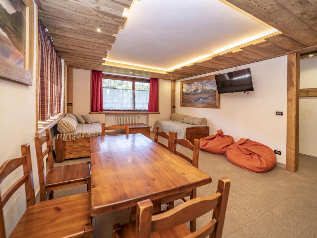ein Esszimmer mit einem Tisch und einem Sofa in der Unterkunft Snug apartment in Sauze d Oulx with fenced garden in Sauze dʼOulx