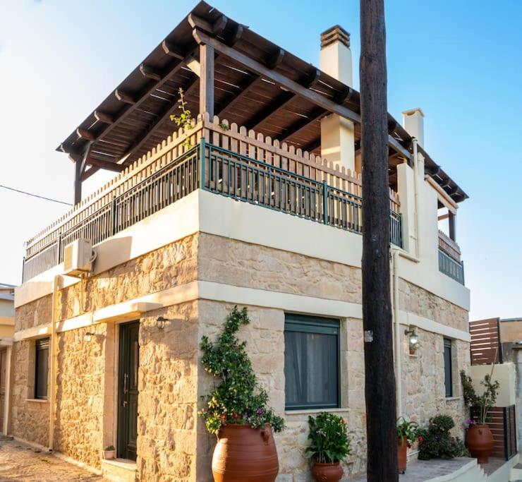 um edifício com uma varanda em cima em Serenity Stone House, a Blissful Retreat em Petrokefalo