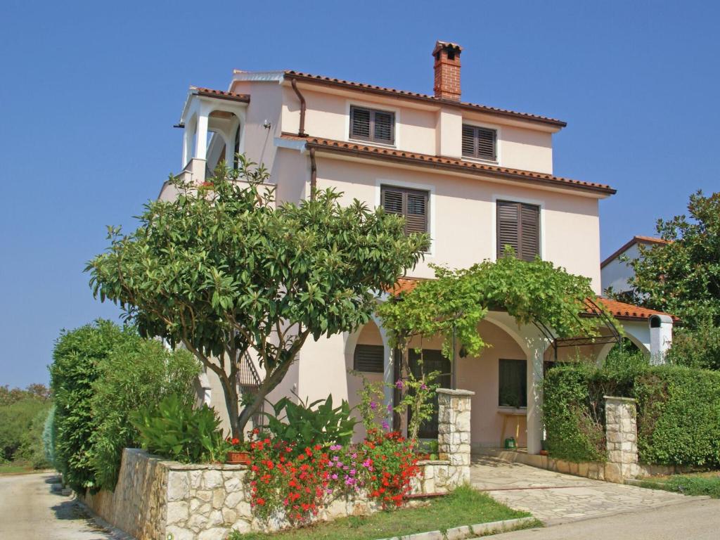 a white house with flowers in front of it at Charming Apartment in Banjole near Sea in Banjole