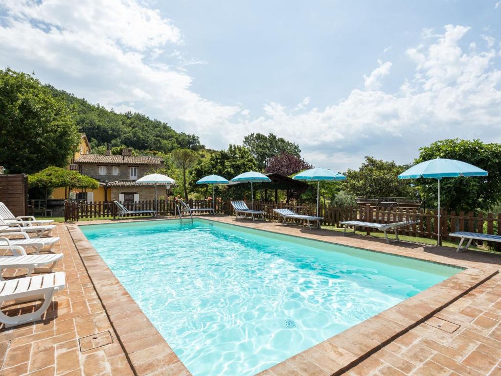una grande piscina con sedie e ombrelloni di Holiday Home in Assisi with Pool ad Assisi