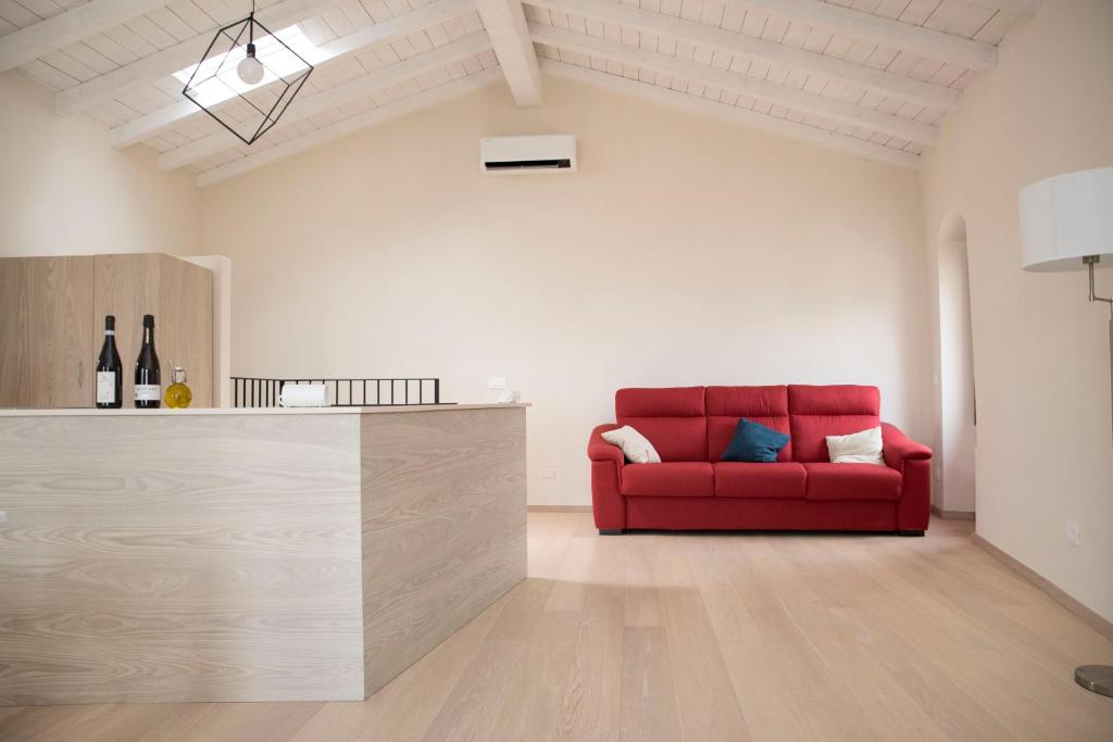 a living room with a red couch and a counter at Ca' de Panaia in Lingueglietta
