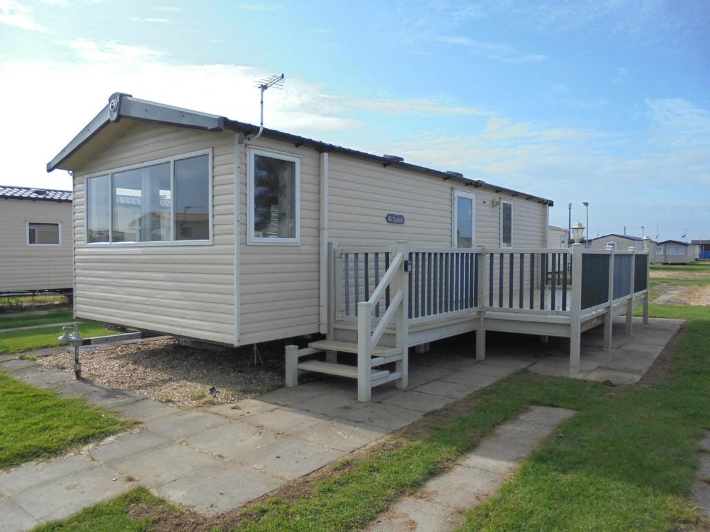 a tiny house with a porch and a deck at Kingfisher : Soleil:- 6 Berth, Central Heated, Close to site entrance in Ingoldmells