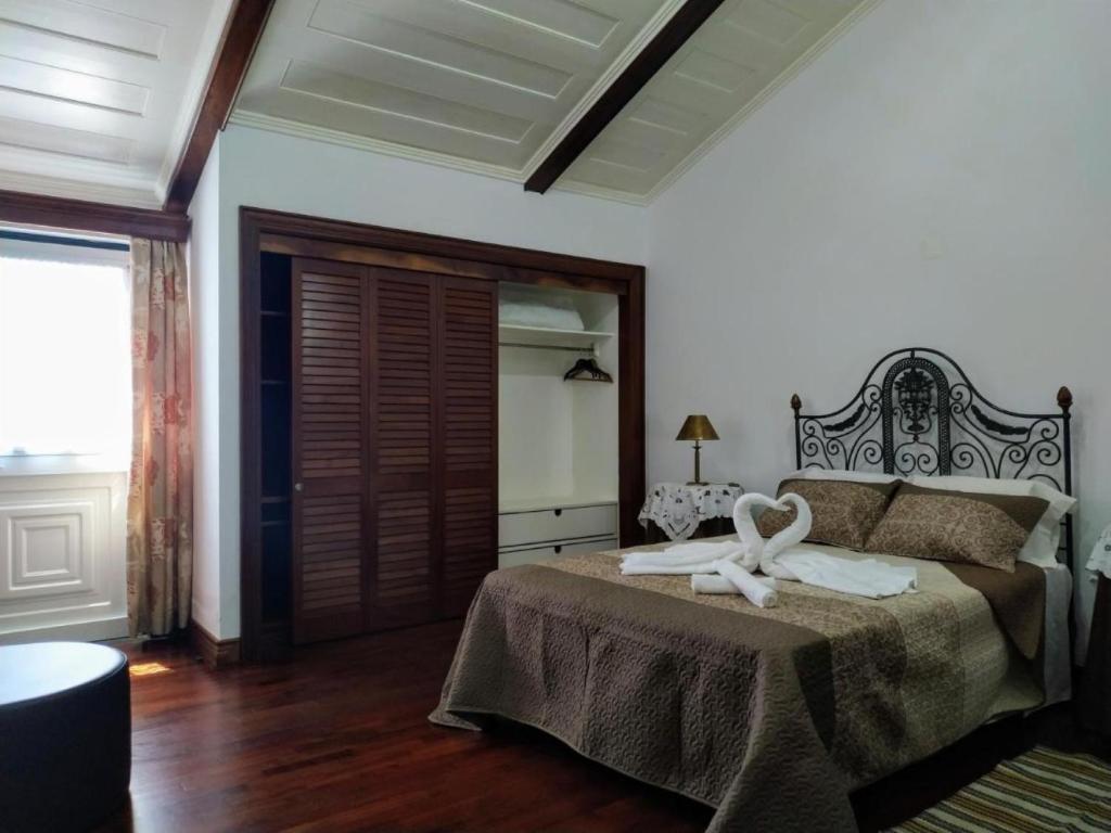 a bedroom with a bed with two swans on it at Bettencourt 2 Rooms in Santa Cruz da Graciosa