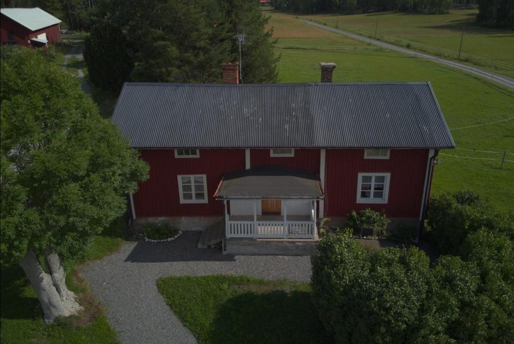 einen Luftblick auf ein rotes Haus mit einer Veranda in der Unterkunft Setons Stuga in Lindesberg