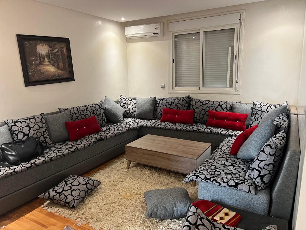 a living room with a gray couch with red pillows at Appartement jad in Casablanca